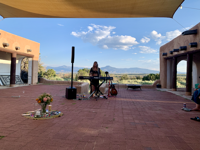 Mary Bue, performing music with a keyboard, outside in the desert